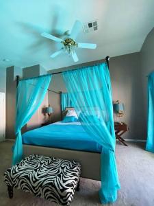 a bedroom with a blue bed with a ceiling fan at J’s amazing pool and hot Jaccuzi sweet house in Las Vegas