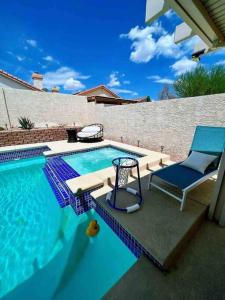 a swimming pool with a blue chair and a chair istg at J’s amazing pool and hot Jaccuzi sweet house in Las Vegas