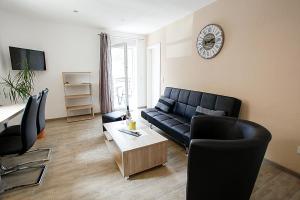 a living room with a couch and a clock on the wall at JG-Haus Ferienwohnungen in Bullay