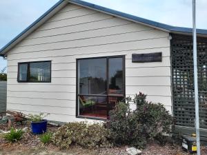 ein weißes Haus mit einem großen Glasfenster in der Unterkunft Rakaia Huts Holiday Home in Southbridge