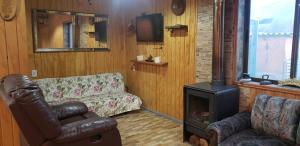 ein Wohnzimmer mit einem Sofa und einem Herd in der Unterkunft Escapada romántica in Pirque