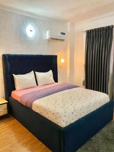 a bed with a blue headboard in a room at WATER VIEW 3 BEDROOM APARTMENT WITH JACUZZI PARKING WiFi NETFLIX POOL in Lekki