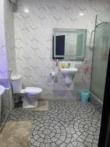 een badkamer met een toilet, een wastafel en een spiegel bij WATER VIEW 3 BEDROOM APARTMENT WITH JACUZZI PARKING WiFi NETFLIX POOL in Lekki