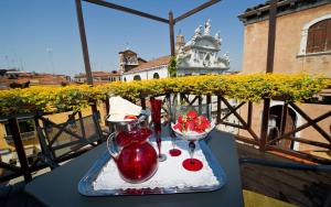 a table with a vase and two glasses on a balcony at Palazzo del Giglio in Venice