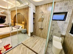 a bathroom with a shower and a bedroom at Gió Homestay - Pleiku in Pleiku