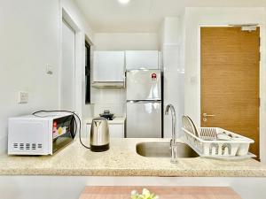 a kitchen with a sink and a refrigerator at 1-8 pax Comfort Place 3room Ara Damansara in Petaling Jaya