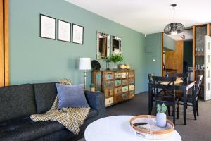 a living room with a couch and a table at Azidene House & Spa Apartment in Daylesford