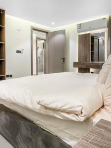 a bedroom with a large white bed with white sheets at GR - A quiet bedroom apartment 10 in Riyadh