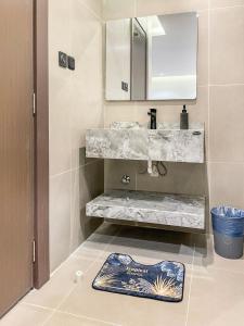 a bathroom with a sink and a mirror and a rug at GR - A quiet bedroom apartment 10 in Riyadh