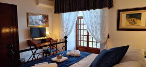a bedroom with a bed and a window and a television at L'Antica Sosta Affittacamere in Colle Umberto