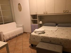 ein kleines Schlafzimmer mit 2 Betten und einem Stuhl in der Unterkunft Appartamento monolocale in Iseo