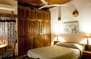 a bedroom with a bed and a table and a desk at Four Villages Inn in Kumasi