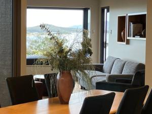 a living room with a table and a vase with a plant at Faraway on Flinders Island 