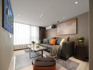 a living room with a couch and a table at East Maple Hotel Apartment - Guangzhou Financial City Sanxi Metro Station in Guangzhou