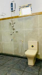 a bathroom with a toilet and a phone on the wall at Sigiriya Chena Villa in Sigiriya