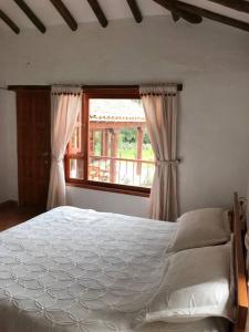 Un dormitorio con una cama grande y una ventana en Casa campestre - Villa de Leyva, en Villa de Leyva