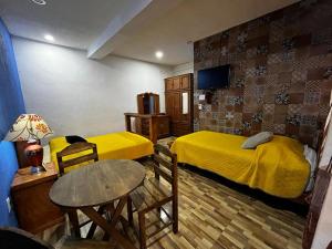 a small room with two beds and a table and a table sidx sidx at Hotel Huasca Terrazza in Huasca de Ocampo