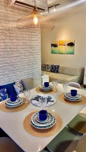 uma mesa de jantar com pratos e copos em Jardim das Palmeiras II Home Resort em Ubatuba