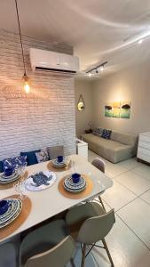 uma cozinha e sala de estar com mesa e cadeiras em Jardim das Palmeiras II Home Resort em Ubatuba