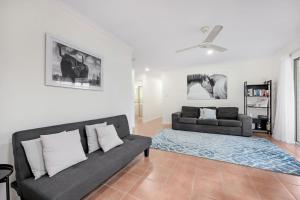uma sala de estar com um sofá e um tapete em 'Hygge' Family-Friendly Comfort in Hervey Bay em Hervey Bay