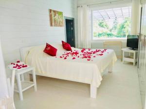 een slaapkamer met een bed met rode rozen erop bij The Sunny Hill Pool Villa 180° Panoramic Sea View 
