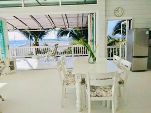 een eetkamer met een tafel en stoelen en het strand bij The Sunny Hill Pool Villa 180° Panoramic Sea View 