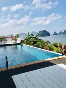 een zwembad met uitzicht op het water bij The Sunny Hill Pool Villa 180° Panoramic Sea View 