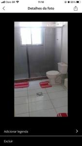 a bathroom with a toilet and a window at Sítio Vô Chico. in Mauá