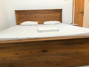 1 cama grande de madera con 2 almohadas en One Bed Room Apartment, en Weligama