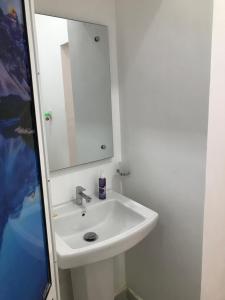 y baño con lavabo blanco y espejo. en One Bed Room Apartment, en Weligama