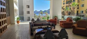 a lobby with couches and chairs and a large window at Ocean View Suites at Corazon Resort in Cabo San Lucas