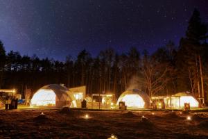 un gruppo di cupole con luci in un campo di notte di HOSHIFULL DOME FUJI a Fujikawaguchiko