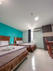 Habitación de hotel con 2 camas y mesa en G Star Hotel, en Pantai Remis