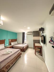 a hotel room with two beds and a television at G Star Hotel in Pantai Remis