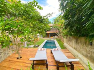 een houten terras met 2 stoelen en een zwembad bij M60 Feet Villa in Madihe East