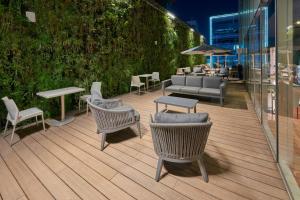 patio z krzesłami, stołami i kanapą w obiekcie City Express Plus by Marriott Santa Fe w mieście Meksyk
