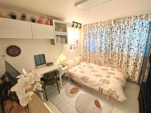 1 dormitorio con cama, escritorio y ordenador en vintage room RED PANDA GUESTHOUSE, en Seúl