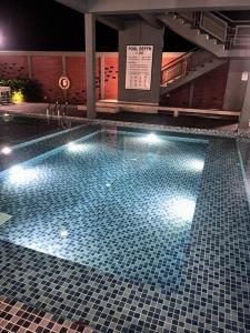 a large swimming pool with lights in a building at Apartment in Sandakan @ Sri Indah Condominium in Sandakan