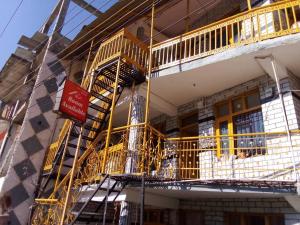 a yellow fire escape on the side of a building at OYO Banka Guest House in Manāli