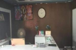 um quarto com um relógio numa parede castanha em OYO Banka Guest House em Manali