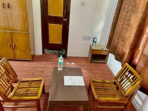 a table and two chairs in a room at OYO Hotel Rohtang View in Manāli