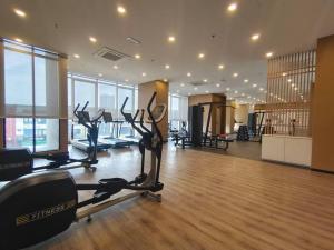 - une salle de sport avec des équipements de cardio-training dans une grande pièce dotée de fenêtres dans l'établissement Skytree A0902-(1) in Foodie City, à Johor Bahru