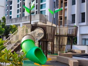 um escorrega verde num parque infantil em frente a um edifício em Skytree A0902-(1) in Foodie City em Johor Bahru