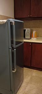 a kitchen with a stainless steel refrigerator and a microwave at THE ROSEMARY SUITE At TIMES SQUARE in Kuala Lumpur