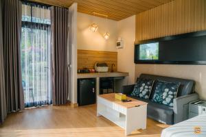a living room with a couch and a table at Naturalpark Resort De Wangthong in Ban Nong Nok Aen