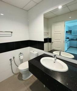 y baño con lavabo, aseo y espejo. en Mansion One Seaview 2BR 2-6pax near GMC Gurney en George Town