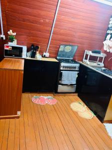 una cucina con piano cottura e pavimento in legno di Aquawood Cabins a Kianyaga