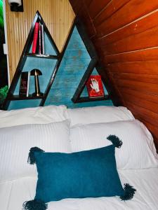 a room with a white bed with a window at Aquawood Cabins in Kianyaga