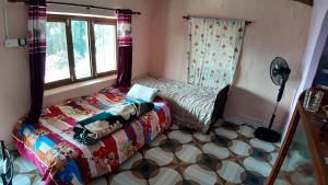 Habitación pequeña con cama y ventana en HIMALAYAN AAMA APARTMENT en Pokhara