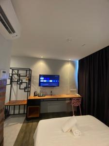 Super 8 Hotel Alor Setar في ألور سيتار: غرفة نوم مع مكتب مع جهاز كمبيوتر على الحائط